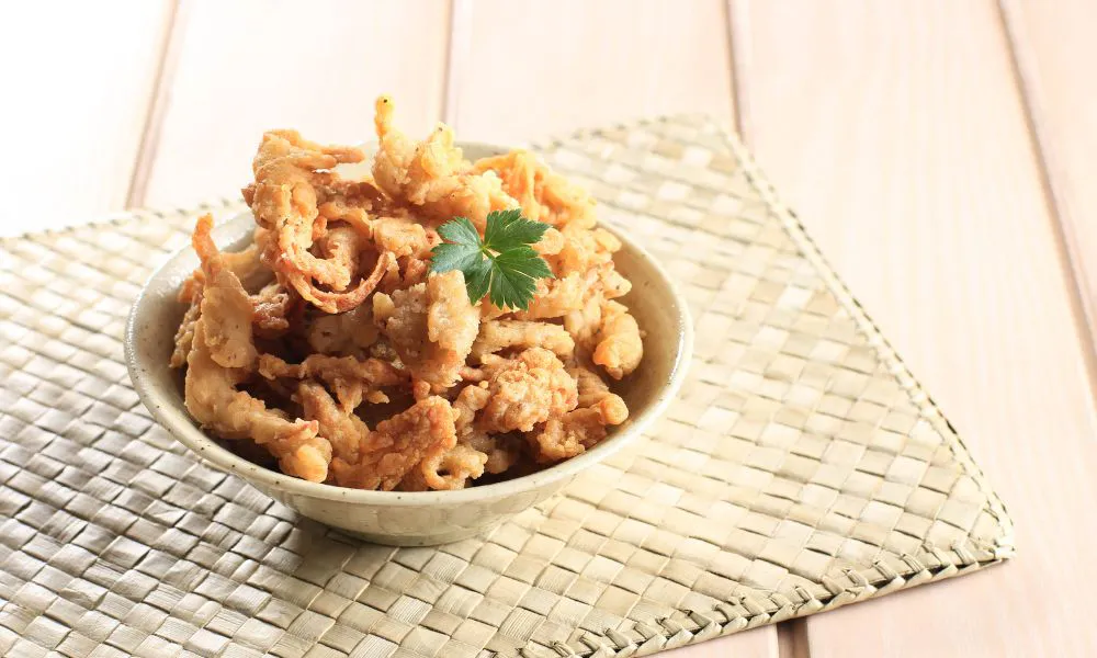 Crispy fried chicken strips garnished with parsley in a bowl at SANKU MAOTS'AI-LA, a Chinese Restaurant in City of Industry