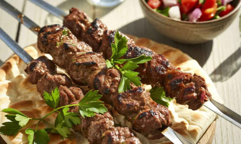 Grilled meat skewers with parsley on flatbread at SANKU MAOTS'AI-LA, a Chinese Restaurant in City of Industry